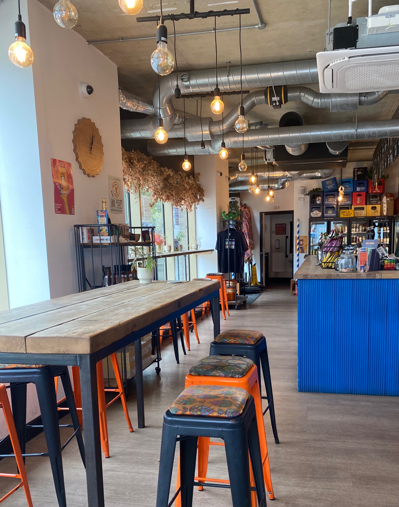 Inside A Hoppy Place — taproom seating with the bar and bottle fridges